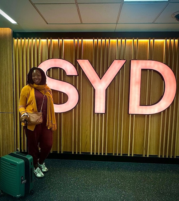 image-of-me-after-my-australia-immigration-experience-standing-infront-of-syd-signage